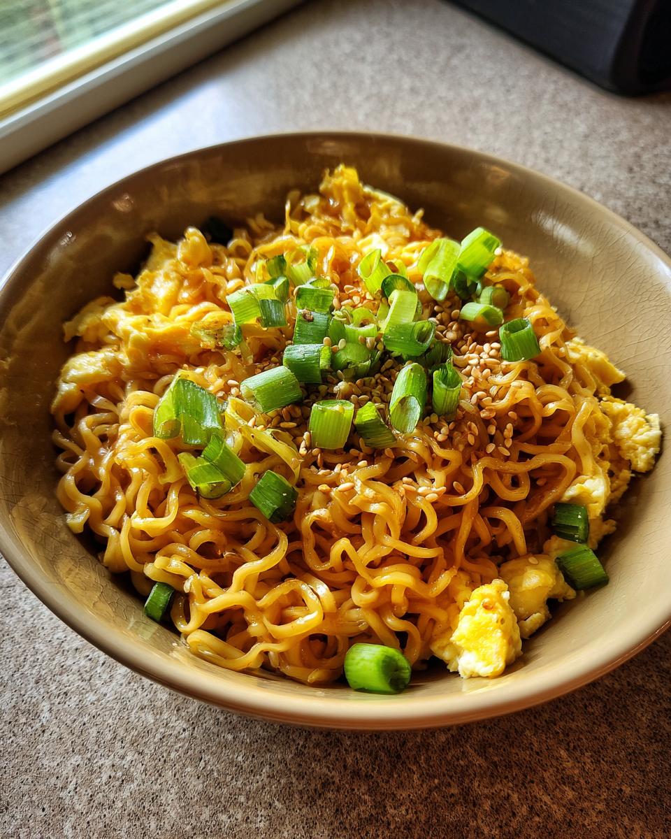 A bowl of TikTok Ramen topped with green onions, sesame seeds, and scrambled eggs.