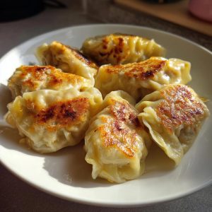 A plate of perfectly pan-fried Traditional Chinese Dumplings, golden brown and ready to eat.