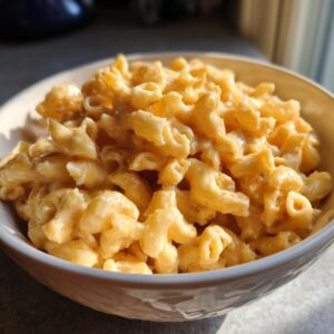 A bowl filled with creamy, cheesy Instant Pot mac and cheese, showing the elbow macaroni coated in a rich cheese sauce.