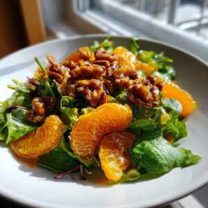 Close-up of a fresh mandarin orange salad featuring bright citrus segments and candied walnuts on mixed greens.